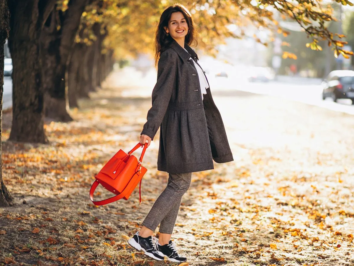 Frau geht durch eine herbstliche Allee spazieren